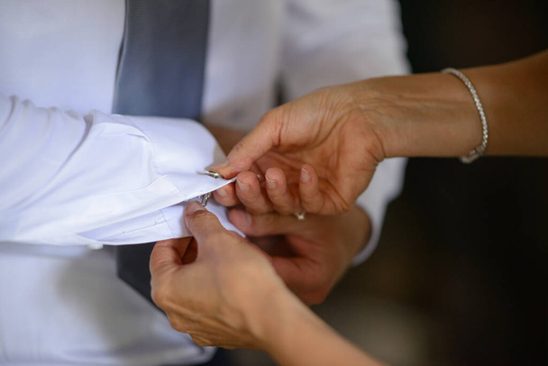 hands buttoning groom's shirt, cropped shot - Фото, изображение
