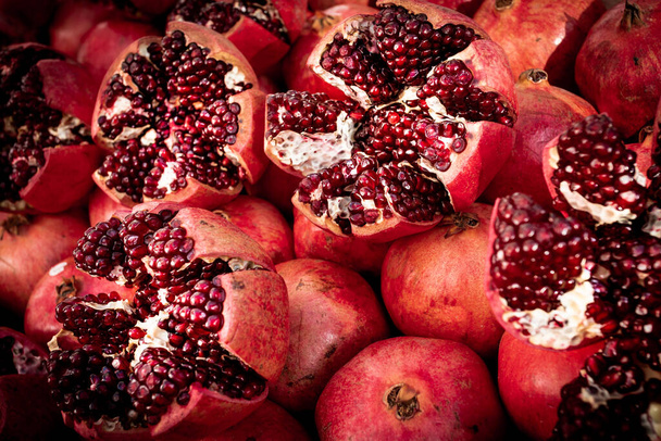 Cracked pomegranate. Ripe Pomegranates Background  - Фото, изображение