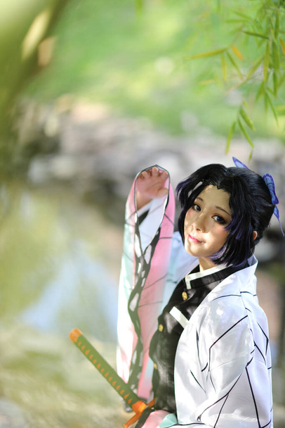 Japan anime cosplay portret van meisje met stripverhaal kostuum met Japanse thema tuin - Foto, afbeelding