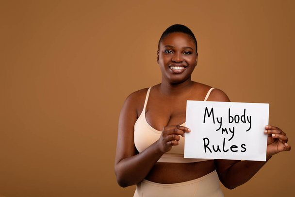 Mein Körper meine Regeln. Kurvige schwarze Frau zeigt Poster - Foto, Bild