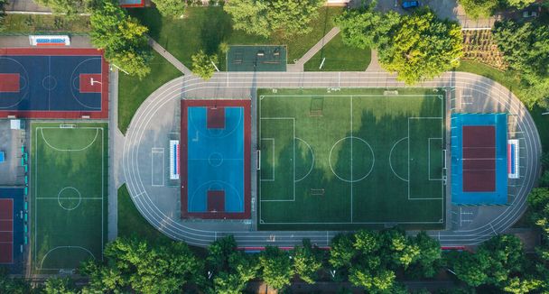 Egy modern terület, gyermek- és sportpályákkal, sportpályával a lakópark udvarán. Közösségi sportpályák csapatjátékokhoz, kosárlabda, futball, röplabda, kézilabda lakóövezetben, légi felvétel - Fotó, kép