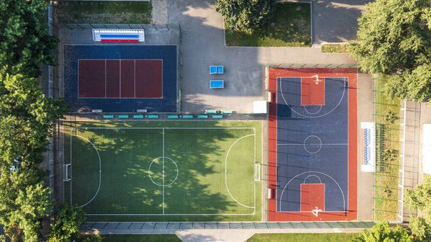 Een modern gebied met een kinder- en sportterrein, een sportterrein op de binnenplaats van het wooncomplex. Sportvelden in de Gemeenschap voor teamwedstrijden, basketbal, voetbal, volleybal, handbal in een woonwijk, luchtfoto - Foto, afbeelding
