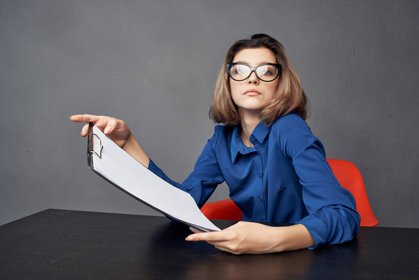 Business woman in blue shirt sits at the table folder in hands documents - Foto, Imagem
