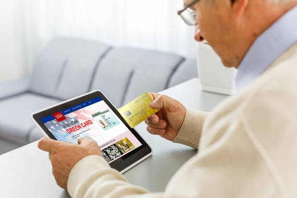 Mann mit Laptop mit United States Permanent Resident Card Webseite - Foto, Bild