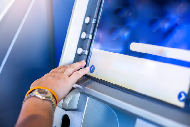 Selective focus to hands choosing option on ATM machine. Customer using ATM an pressing button on the keyboard automatic teller machine. - Photo, Image