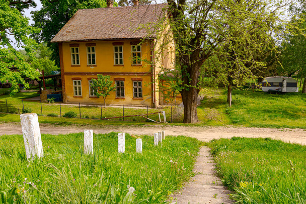 Ivanovo, Vojvodina, Serbia - 17. huhtikuuta 2016: Vanha asuinrakennus keltaisella julkisivulla koristeikkunoilla, vanhan rakennuksen ulkopuoli. - Valokuva, kuva