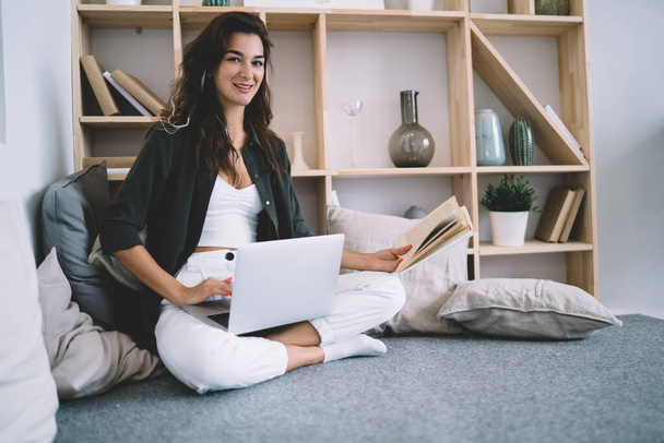 Portrait of cheerful caucasian female enjoying learning online course sitting at modern interior apartment, smiling 20s woman freelancer share content in blog working remotely at home interior - Foto, Imagem