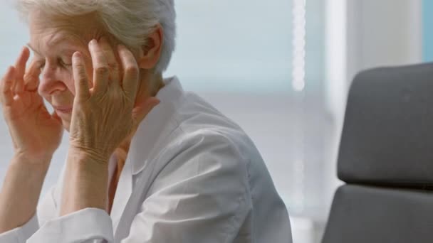 Arzt massiert an Kopfschmerzen leidende Schläfen in Klinik - Filmmaterial, Video
