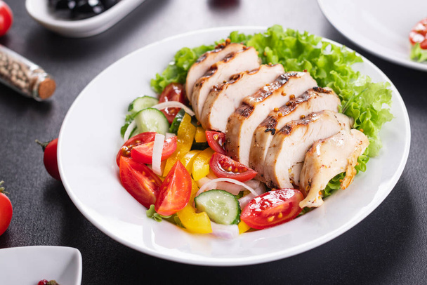 salad grilled chicken breast vegetables tomato, cucumber, onion, pepper outdoor meal snack on the table copy space food background rustic. top view keto or paleo diet  - Photo, Image