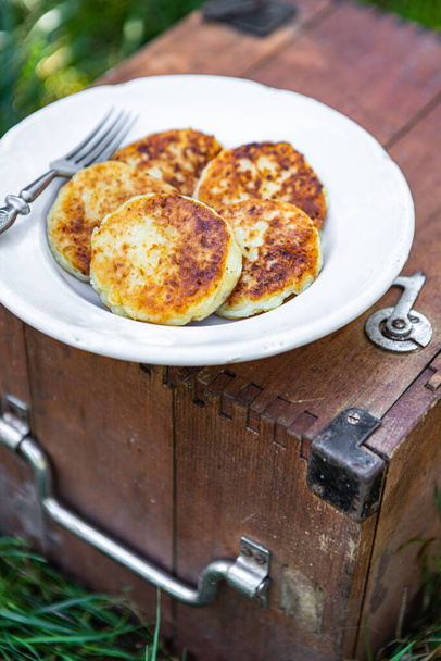 syrniki zoete pannenkoeken cottage kaas ontbijt buiten maaltijd snack op de tafel kopiëren ruimte voedsel achtergrond rustiek top uitzicht  - Foto, afbeelding