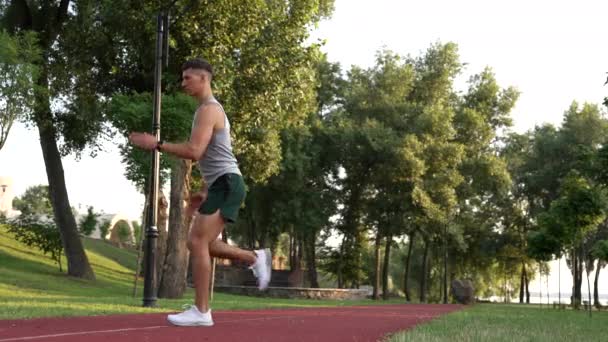 homem muscular aquecimento com back lunge exercício ao ar livre, treinamento - Filmagem, Vídeo