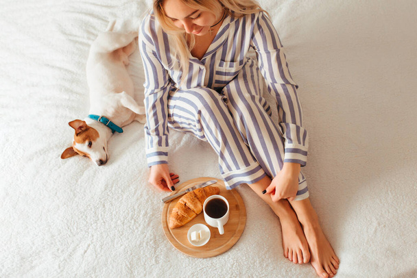 morning breakfast in bed croissant and coffee. next to her is a woman in pajamas . top view - Photo, Image