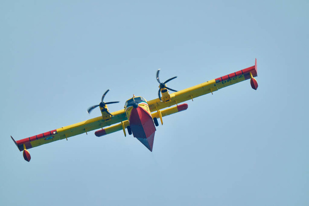Ιταλία, Σικελία, Marina di Ragusa (επαρχία Ragusa), ένα ιπτάμενο πυροσβεστικό αεροπλάνο Canadair να πάρει θαλασσινό νερό για να σταματήσει μια πυρκαγιά κοντά στην ύπαιθρο - Φωτογραφία, εικόνα