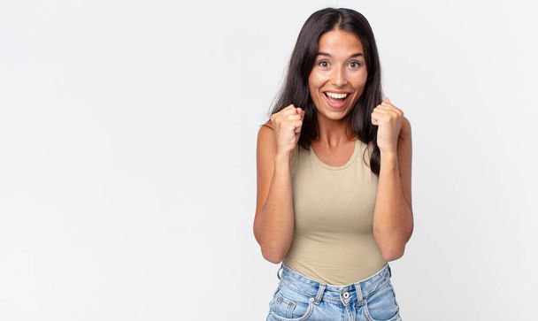 pretty thin hispanic woman feeling shocked,laughing and celebrating success - Foto, afbeelding