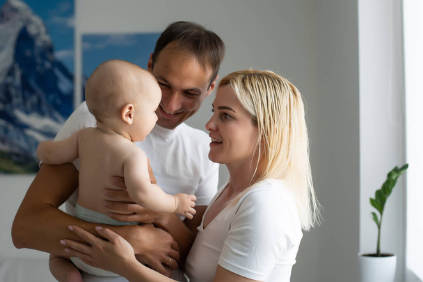 Retrato de padres jóvenes felices con bebé en casa - Foto, imagen