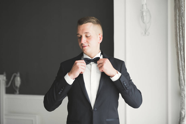 Grooms morning preparation. Handsome man getting dressed and preparing for the wedding - Foto, imagen