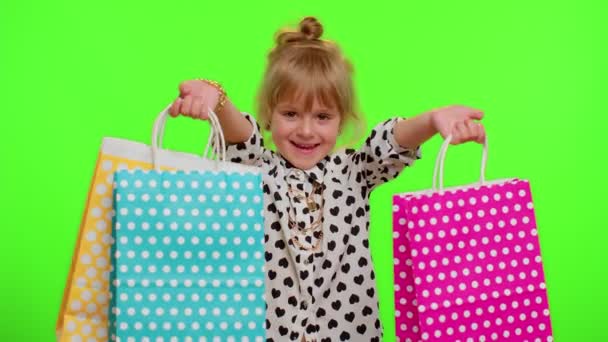 Kid tyttö näyttää ostoskassit, mainonta alennukset, alhaiset hinnat, ostoksia Black Friday vapaapäivät - Materiaali, video