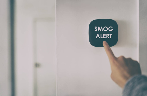 Smog warning on smart home air quality touchscreen indoor AQI screen alert. Woman touching domotic device inside house. - Фото, изображение
