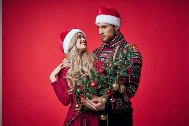 retrato de una joven pareja en un abrazo navidad fondo rojo - Foto, imagen