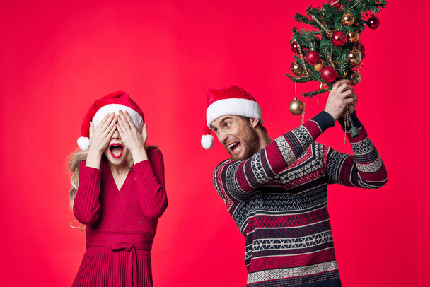 χαρούμενο νεαρό ζευγάρι Χριστούγεννα διακόσμηση κόκκινο φόντο διακοπές - Φωτογραφία, εικόνα