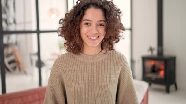 sorridente giovane bruna con capelli ricci in posa - Filmati, video