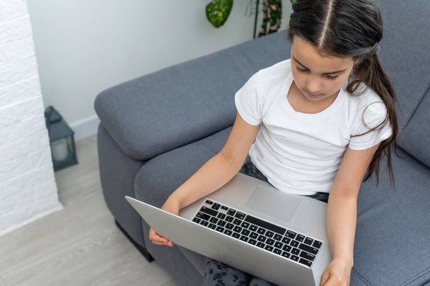 Een klein meisje studeert online. Quarantaine. Online. - Foto, afbeelding