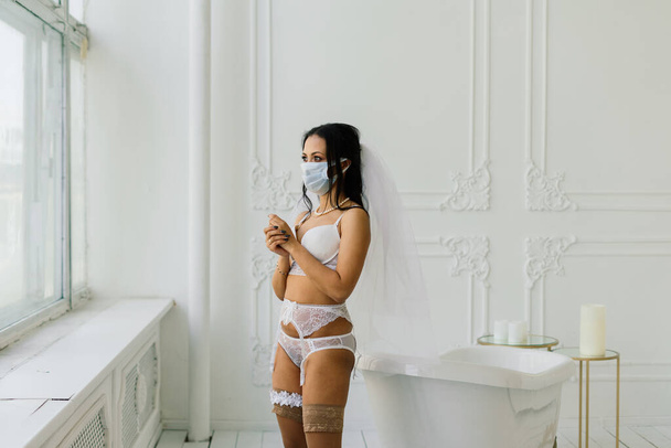 African American bride in lingerie, mask and in morning preparing for the wedding in hotel room - Фото, зображення