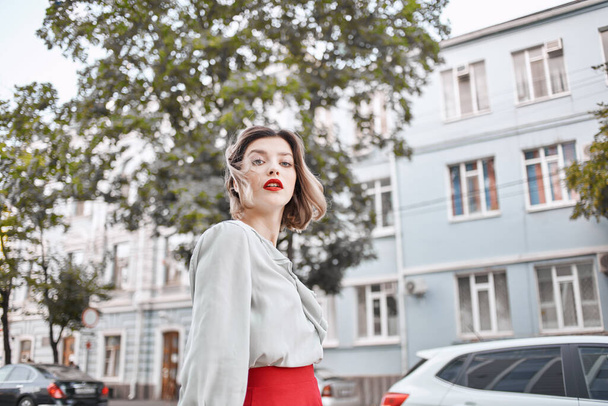 ブロンド女性で赤いスカート屋外で歩く新鮮な空気のライフスタイル - 写真・画像