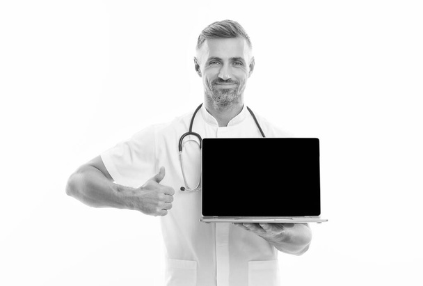 man therapist with laptop. medical worker with stethoscope show thumb up. technology in modern medicine. make an appointment with doctor online. physician consultation on covid. Your personal account - Фото, изображение