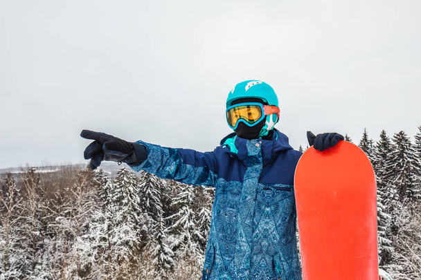 Persona con una tabla de snowboard en la estación de esquí - Foto, Imagen