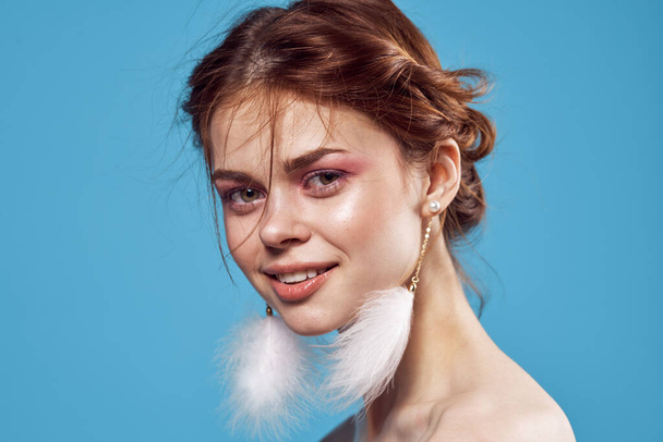 γυναίκα με γυμνούς ώμους φωτεινό μακιγιάζ χνουδωτά σκουλαρίκια μοντέλο - Φωτογραφία, εικόνα