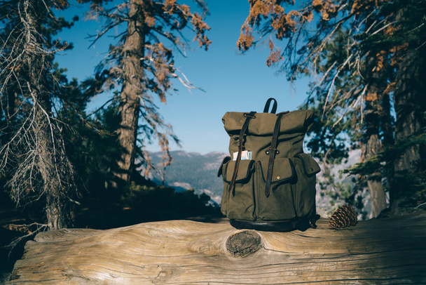 Trendy rucksack with roll top and pockets in national park for transporting stuff during hiking and exploring tour,backpack with equipment on active leisure and tourism in mountains environment - Foto, afbeelding
