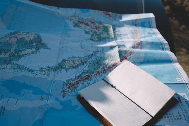 Карта и блокнот с пустыми страницами для планирования и написания идей для изучения и туристического тура, географическая карта с маршрутом и направлением для путешествия туристического оборудования для туристического тура - Фото, изображение