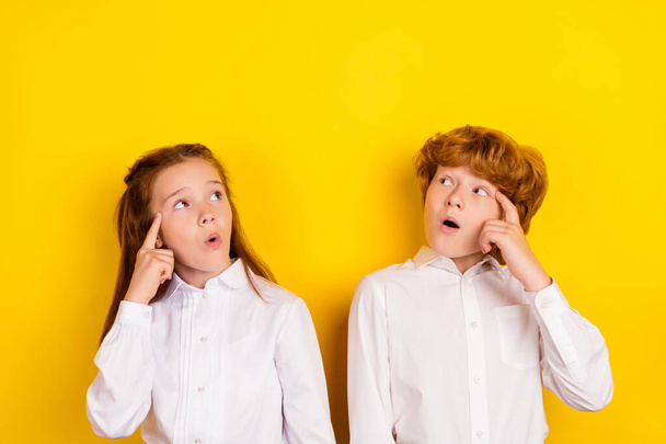 Portrait of brother and sister school pupils look copyspace thinking find idea solution isolated on yellow color background - Φωτογραφία, εικόνα