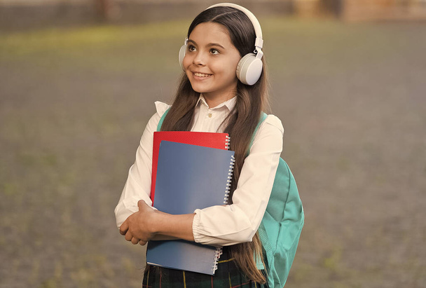 Music is universal language of mankind. Happy child listen to music outdoors. Little kid wear headphones playing music. Music school. New technology. Modern life. Education and learning. Ear training - Foto, immagini