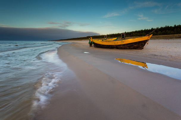 Un barco pesquero de madera amarrado por la playa de Debki, amanecer. Mar Báltico, norte de Polonia. - Foto, Imagen