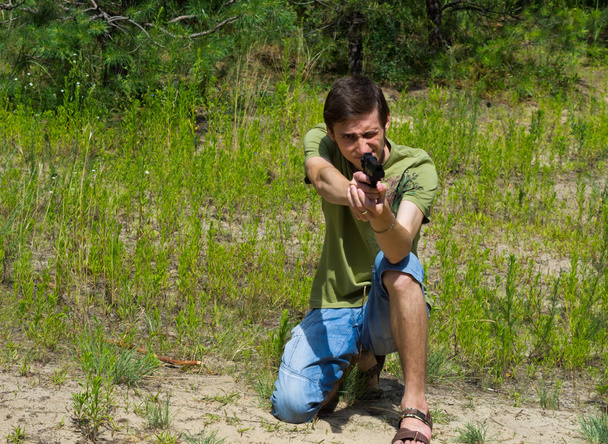 Retrato de un joven apuntando con una pistola neumática
 - Foto, Imagen