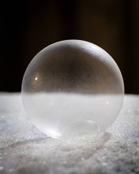 A closeup shot of a glass sphere on a glittery surface - Fotoğraf, Görsel