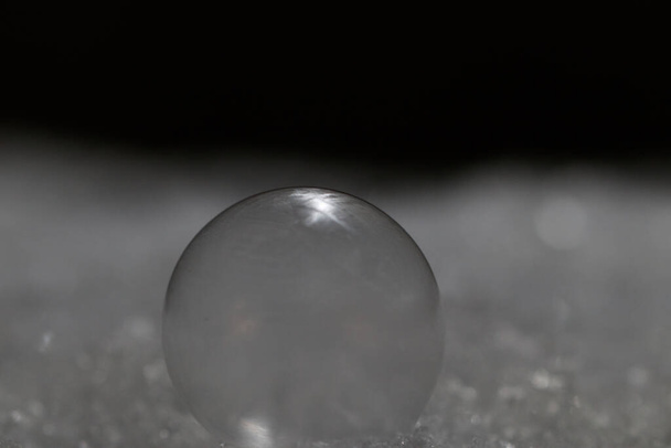 A closeup shot of a glass sphere on a glittery surface - 写真・画像