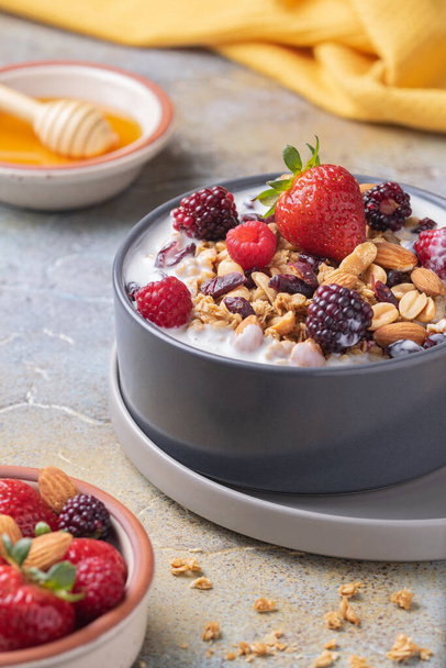 A closeup of a bowl of sweet fresh yogurt with cereal and fruits - Photo, image