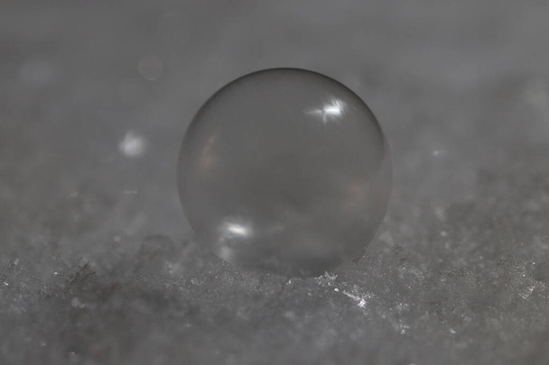 A closeup shot of a glass sphere on a glittery surface - Φωτογραφία, εικόνα