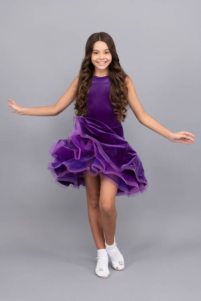 αρκετά χαρούμενος παιδί με μακριά σγουρά μαλλιά χορό σε αίθουσα χορού φόρεμα πλήρους μήκους, performer - Φωτογραφία, εικόνα