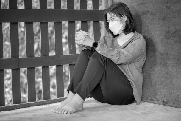 Μια νεαρή γυναίκα να κάθεται μόνη και θλιμμένη. Η κατάθλιψη γυναίκα κάθεται στο πάτωμα, κακοποίηση και οι άνθρωποι έννοια - Φωτογραφία, εικόνα