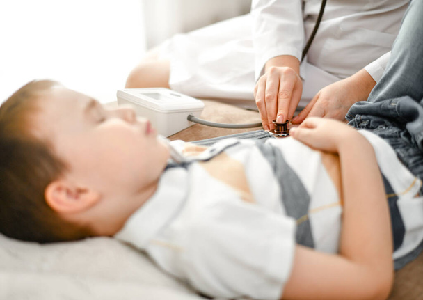 The doctor measures the pressure of a sick child with a tonometer. - Foto, Bild