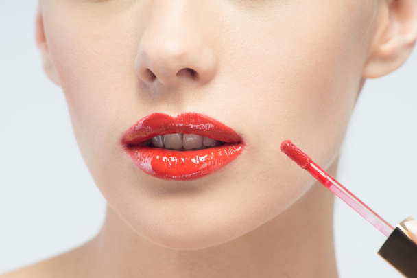 Beautiful woman applying lip gloss - Foto, immagini