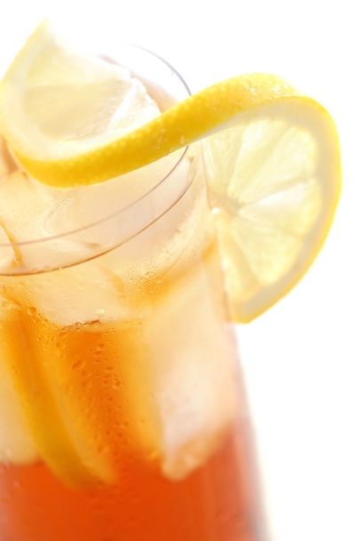 Glass of cold lemon iced tea with ice, lemon and water drops on glass surface - Foto, imagen