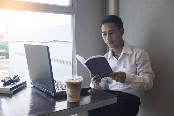 Asiatischer Geschäftsmann liest Buch im Café - Foto, Bild