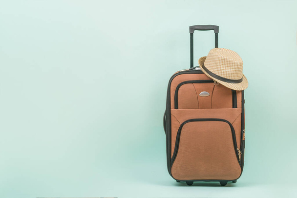 Utazó bőrönd, kék hátterű férfi sapkával. Helyet a szövegnek. A nyári utazás fogalma. - Fotó, kép