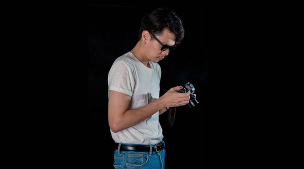 Retrato de homens segurando um DSLR olhando câmera no escuro estúdio fundo, asiático - Foto, Imagem