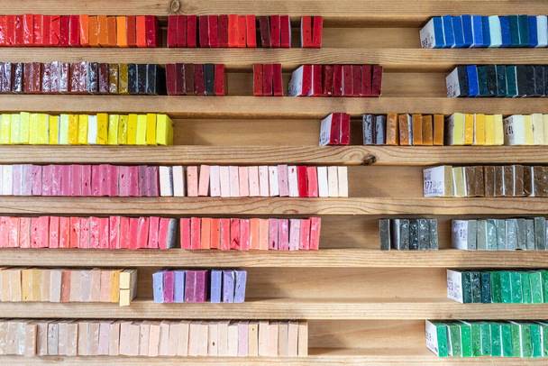 A big wooden shelf with different color watercolor boxes - Foto, afbeelding